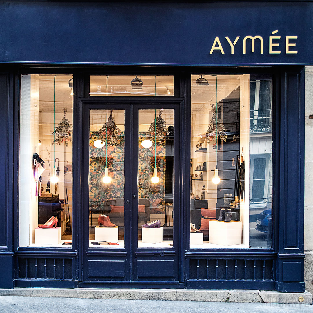 Réalisé par Aymée : enseigne boutique de chaussures à Paris, lettres découpées en aluminium-dibond brossé doré (épaisseur 3 mm), fixation sur entretoises avec gabarit de perçage.