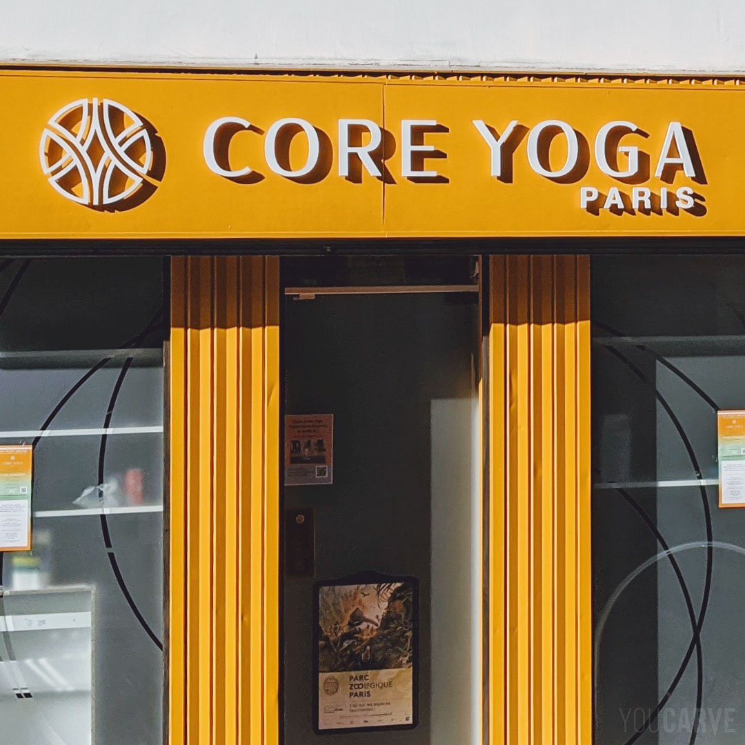Réalisé par Core Yoga : enseigne centre de yoga et pilates à Paris, lettres et logo découpés sur-mesure en PVC expansé blanc épaisseur 19 mm, fixation sur entretoises avec gabarit de perçage.