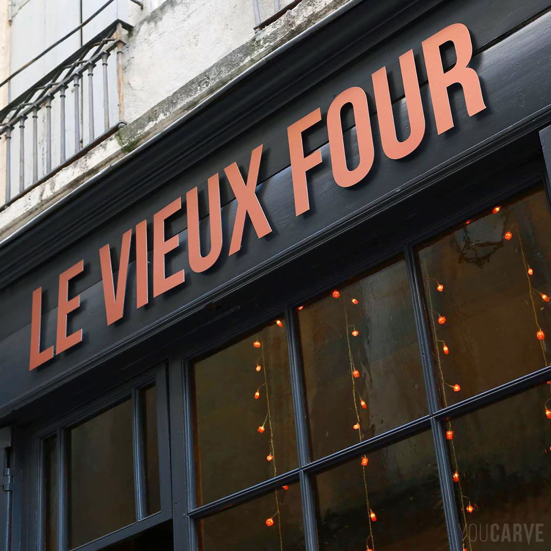 Réalisé par Le Vieux Four : enseigne restaurant à Montpellier, lettres découpées en aluminium-dibond brossé cuivré (épaisseur 3 mm), fixation sur entretoises avec gabarit de perçage