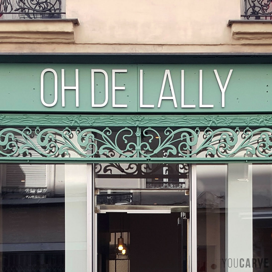 Réalisé par Oh De Lally : enseigne café salon de thé à Paris, lettres découpées en aluminium-dibond laqué blanc mat (épaisseur 3 mm), fixation sur entretoises avec gabarit de perçage.