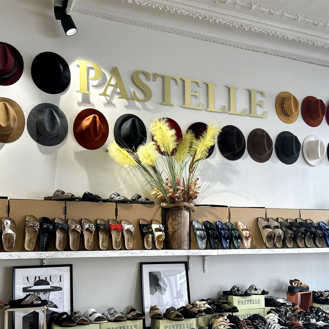 Réalisé par Pastelle Paris : enseigne magasin de chaussures, lettres découpées en aluminium-dibond brossé doré (épaisseur 3 mm), fixation sur entretoises avec gabarit de perçage.