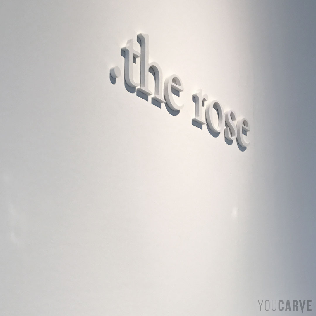 Réalisé par The Rose (créateur de bijoux à Paris) : logo mural en relief ton sur ton, découpe en PVC expansé blanc