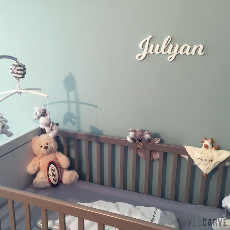Prénom enfant/bébé (Julyan) en PVC expansé blanc, fixation double-face sur le mur de la chambre.