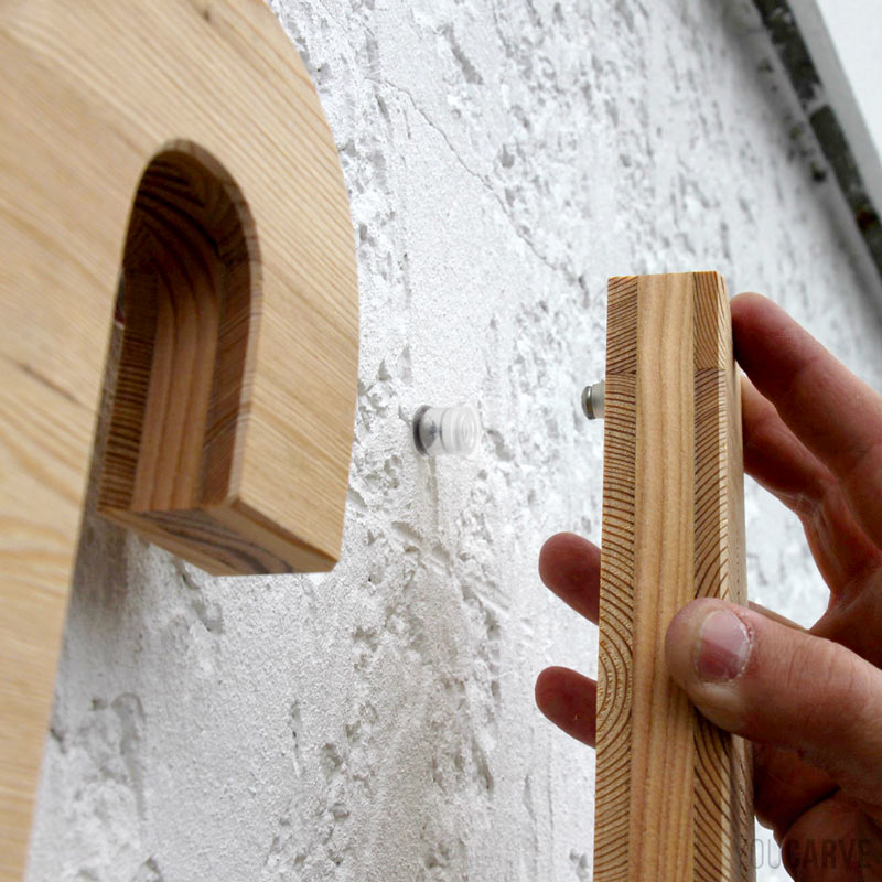 Installation enseigne - Etape 4a - Clipsage des lettres en bois Zoom sur le clipsage d'une lettre, vue rapprochée sur le tenon (partie mâle) qui s'insère dans la douille (partie femelle)