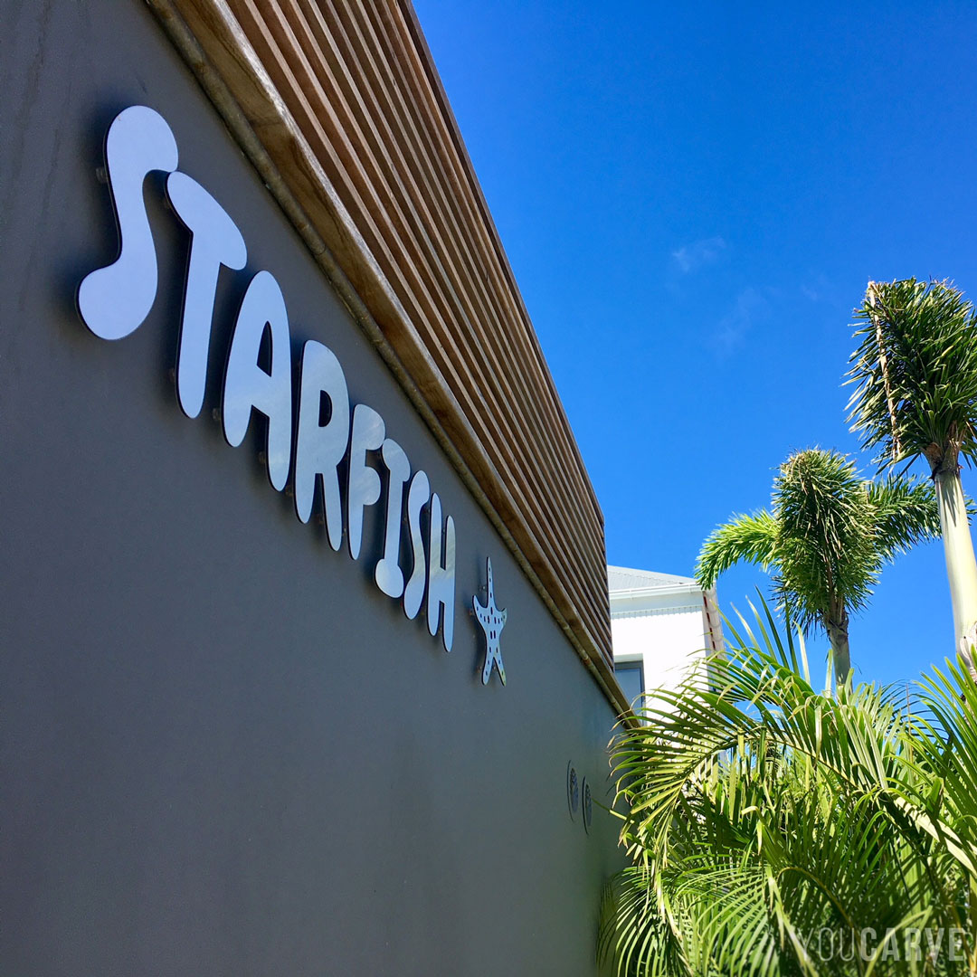 Réalisé par Villa Starfish : enseigne pour la location de villa de luxe à Saint-Barthelemy, lettres découpées en dibond aluminium brossé (épaisseur 3 mm), fixation sur entretoises avec gabarit de perçage.