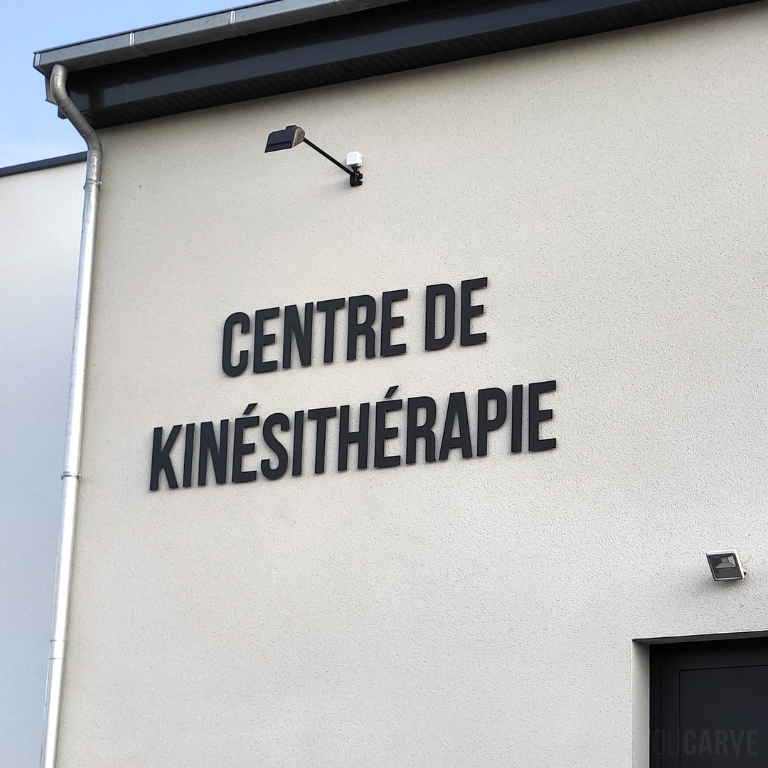 Réalisé par le Centre de kinésithérapie de Vaucelles : enseigne en façade avec l lettres découpées en aluminium-dibond laqué noir mat (épaisseur 3 mm), fixation sur entretoises avec gabarit de perçage.