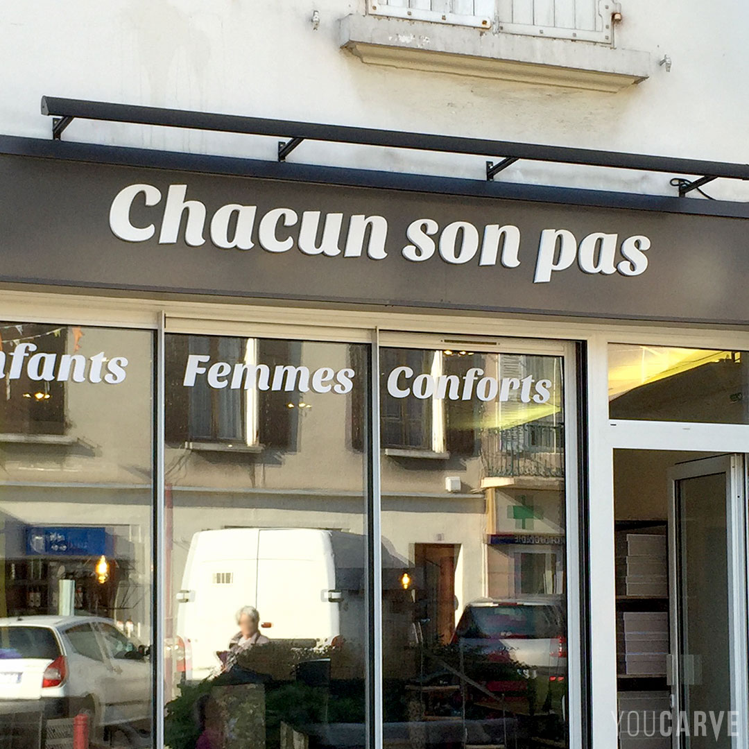 Réalisé par Chacun son pas, enseigne magasin de chaussures, lettres découpées en PVC expansé blanc épaisseur 19 mm avec chanfreins, fixation mousse-double-face avec gabarit de positionnement.