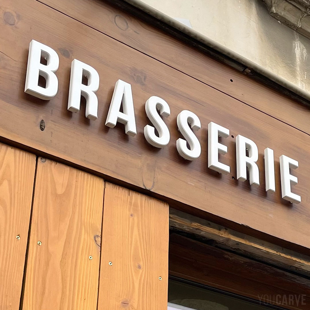 Réalisé par Chez Fernand : enseigne brasserie-traiteur à Monestier-de-Clermont, lettres découpées en PVC expansé blanc épaisseur 19 mm avec chanfreins, fixation sur entretoises avec gabarit de perçage