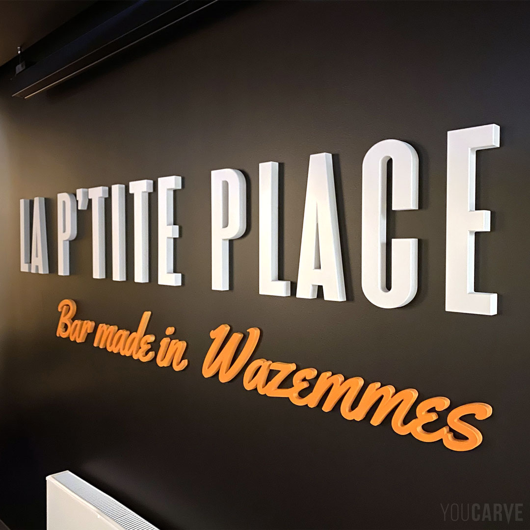 Réalisé par La P’tite Place (bar-pizzeria, à Lille) : enseigne intérieure / logo mural en relief, découpe sur-mesure en PVC expansé blanc épaisseur 19 et 30 mm avec finition chanfreinée et fixation mousse-double-face. Mise en couleur et installation par notre client.