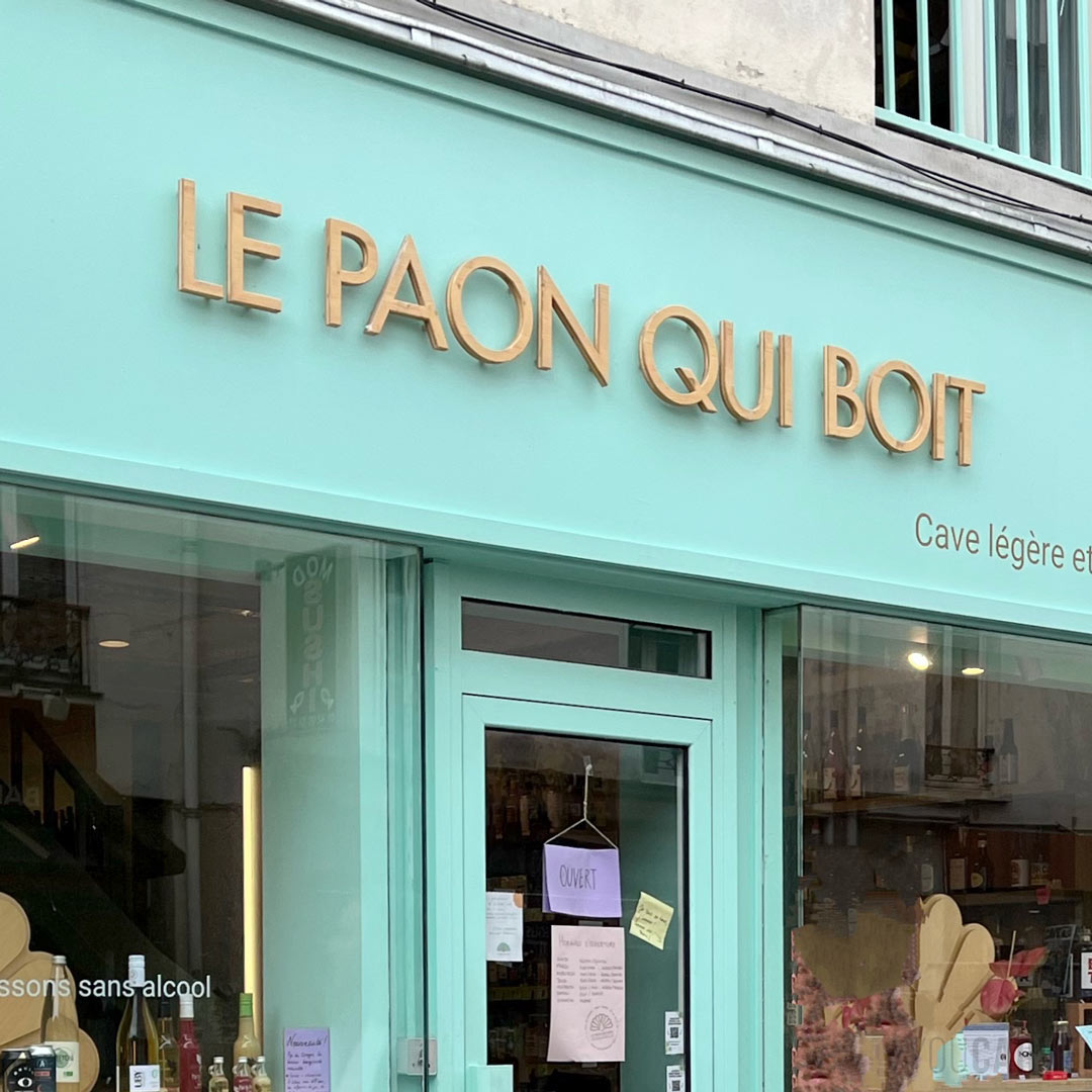 Le Paon Qui Boit - Enseigne lettres découpées en bois (épicéa) Enseigne de magasin 'Le Paon Qui Boit' avec des lettres découpées en bois (épicéa 3 plis) installées avec fixations sur entretoises clipsables