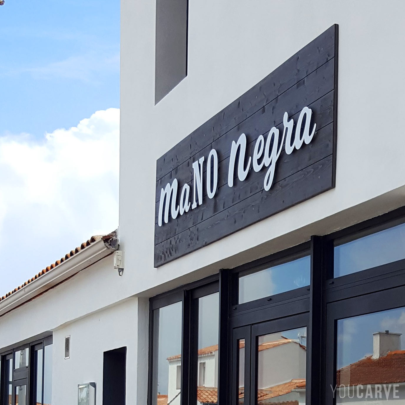 Réalisé par La Mano Negra : enseigne restaurant pizzeria à Noirmoutier, lettres découpées en aluminium-dibond laqué blanc mat (épaisseur 3 mm), fixation sur entretoises avec gabarit de perçage.