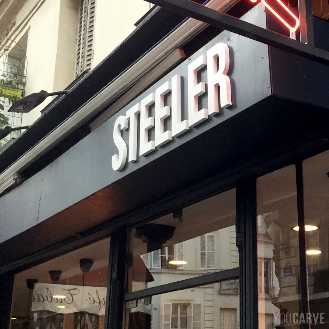 Réalisé par Steeler : enseigne coutellerie à Paris, lettres découpées en PVC expansé blanc épaisseur 19 mm, fixation mousse-double-face avec gabarit de positionnement.