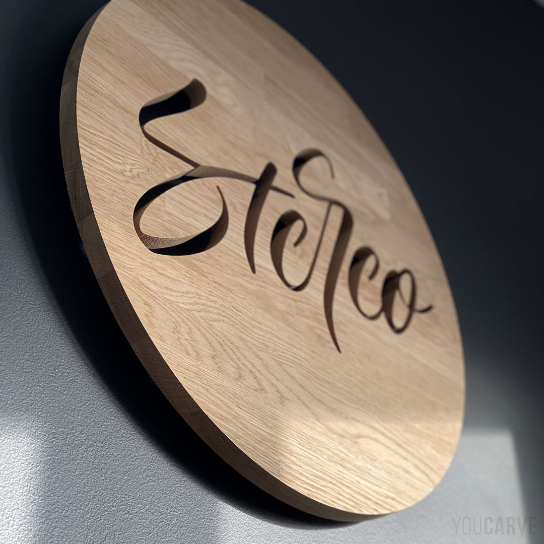 Réalisé par Stereotype (fonderie numérique et typographe français) : logo mural en bois, découpe sur-mesure en chêne épaisseur 19 mm, fixation sur entretoises avec gabarit de perçage.