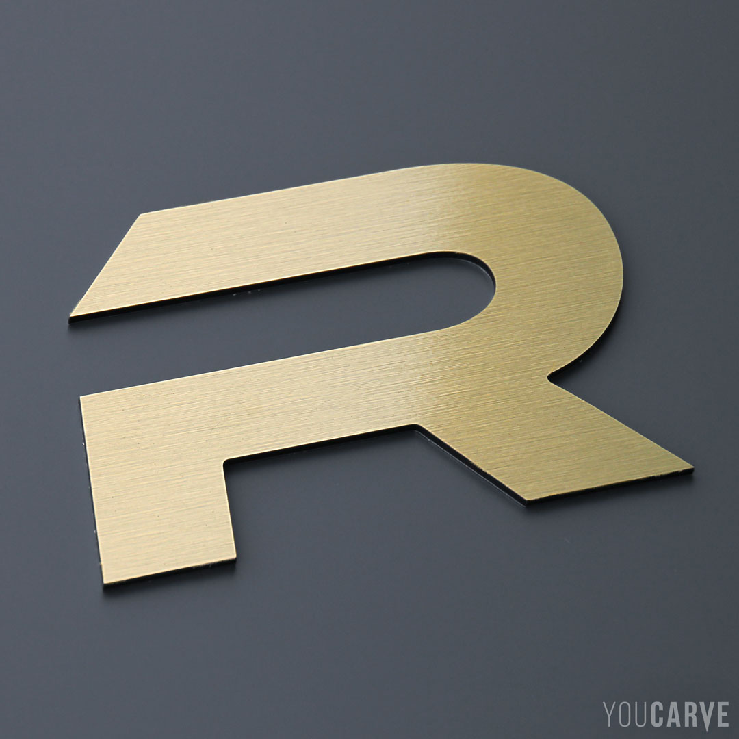 Lettre R découpée en aluminium-dibond brossé doré (épaisseur 3 mm), pour l’enseigne et la signalétique.