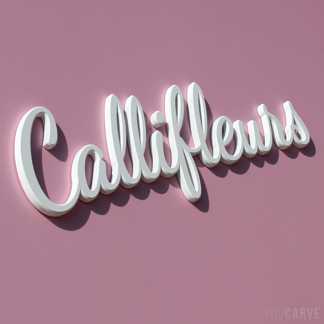 Réalisé par Callifleurs (fleuriste) : logo mural en relief, découpe sur-mesure en PVC expansé blanc épaisseur 10 mm avec chanfreins, fixation mousse-double-face.