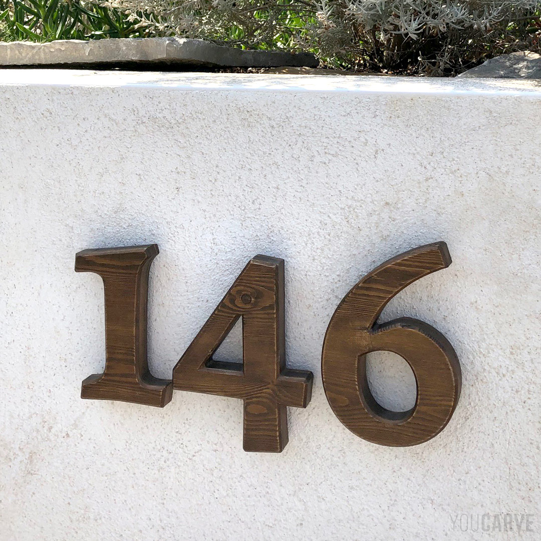 Numéro de maison/rue, chiffres en bois (mélèze épaisseur 19 mm), fixation sur entretoises avec gabarit de perçage, lasure et installation réalisées par notre client.